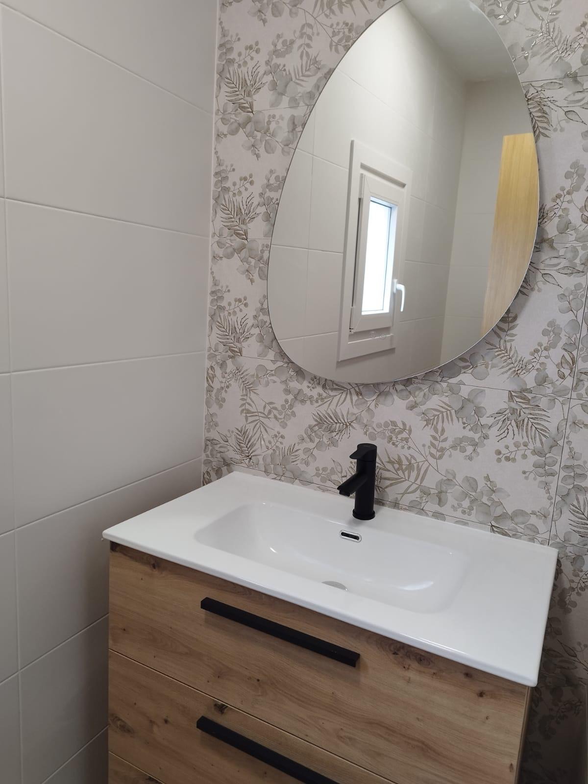Baño reformado por Dilau Camiños con diseño funcional y acabados modernos en Galicia